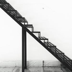 Empty metal staircase by wall