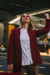 Young woman tossing hair while standing on road