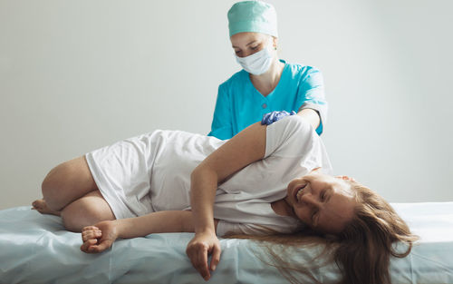 Female doctor examining patient at home