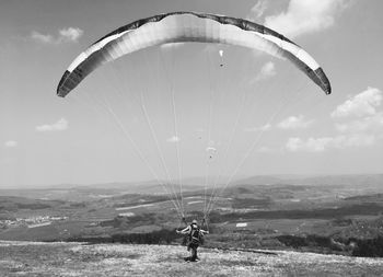 Person paragliding against sky