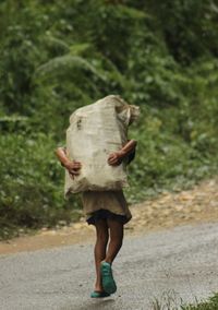 Rear view of woman walking on road