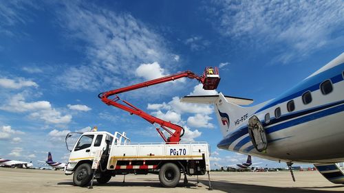 Low angle view of airplane at airport runway against sky