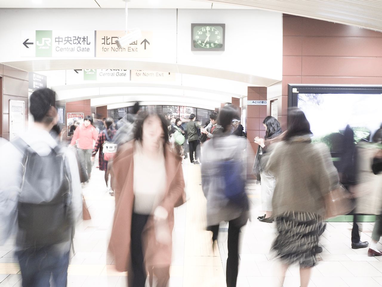blurred motion, large group of people, motion, walking, real people, women, crowd, text, lifestyles, speed, men, public transportation, railroad station, transportation, casual clothing, indoors, commuter, rush hour, day, architecture, clock, adult, people