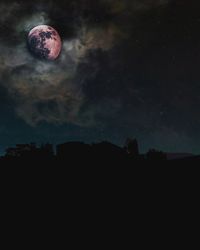 Low angle view of silhouette moon against sky at night