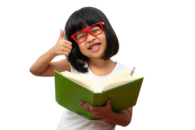 Young woman holding book against white background