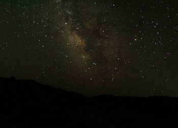 Low angle view of silhouette mountain against sky at night