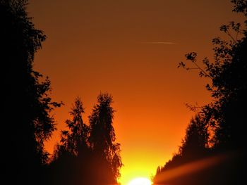 Low angle view of silhouette trees against romantic sky