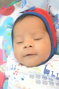 High angle view of baby boy sleeping on bed at home