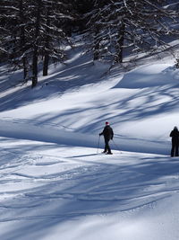 People skiing on snow covered field