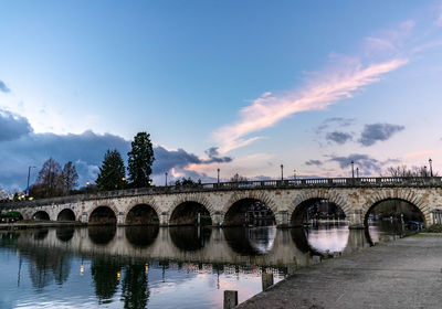 Arch bridge over river against sky