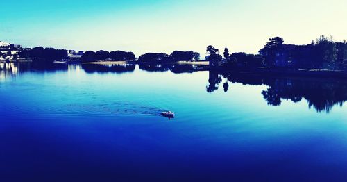 Scenic view of lake against clear blue sky