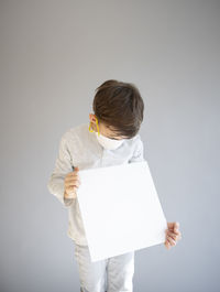Full length of man holding paper against white background