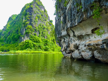 Scenic view of rocks by lake against sky