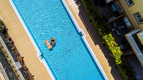 Aerial view of senior couple relaxing in swimming pool