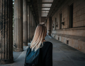 Rear view of woman standing in corridor 