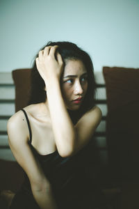 Portrait of young woman sitting at home