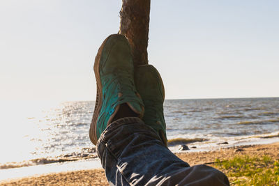 Low section of man relaxing on beach