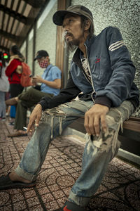 Man smoking cigarette while siting on seat