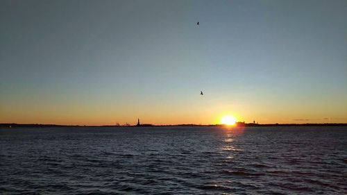 Scenic view of sea against clear sky during sunset