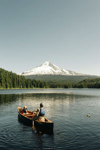 A father canoes with his daughter on trillium lake near mt. hood, or.