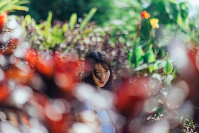 Young woman with plants in foreground