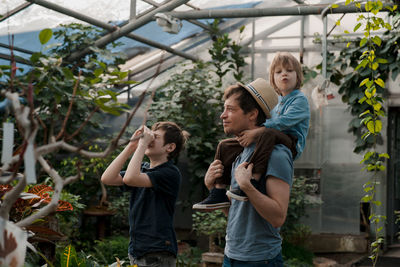 Adventurous family inspecting tropical gallery in botanical garden. local travel