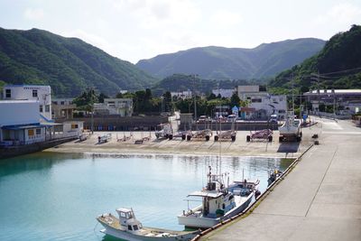 Boats moored in lake against buildings in city