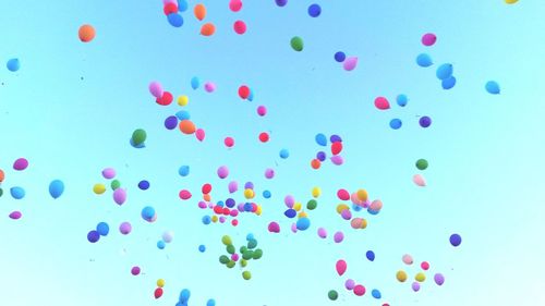 Low angle view of balloons against blue background