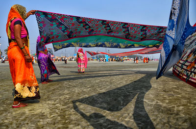Women in traditional clothing holding colorful fabric