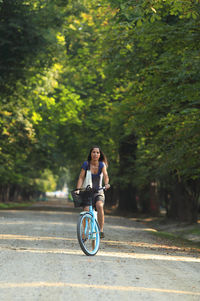 Portrait of mid adult woman riding bicycle on road