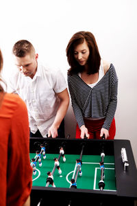 Friends playing foosball in studio 