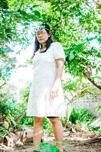 Full length of woman standing against tree