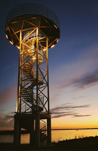 Low angle view of illuminated tower against sky during sunset