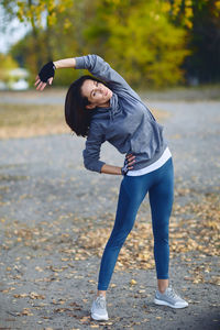 Full length of young woman standing on footpath