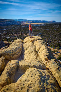 Woman stand at the edge of a cliff surveying ancient lava flows at el mapais national monument.