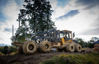 Low angle view of machinery on field against sky