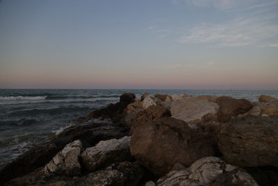 Scenic view of rocks on beach against sky