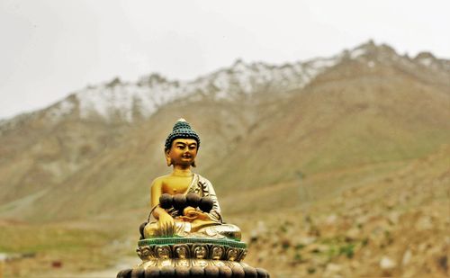 Buddha statue against mountains