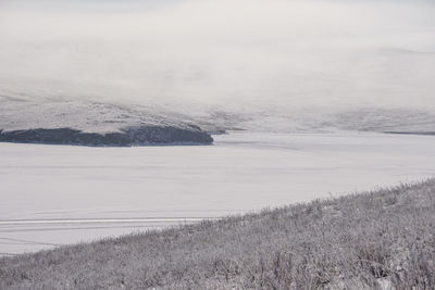 Scenic view of lake against sky during winter