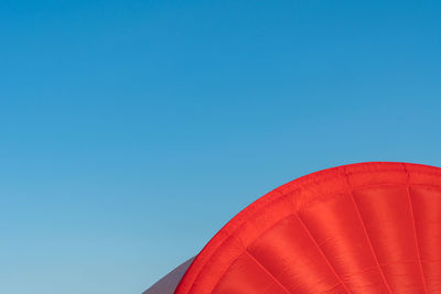 Low angle view of red hot air balloon against blue sky