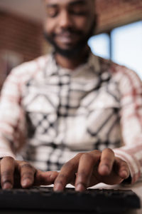 Midsection of man using mobile phone