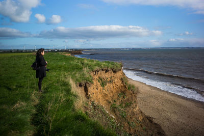 Rear view of man on beach against sky