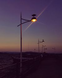 Silhouette street light against sky at night