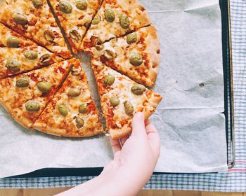 Cropped hand having pizza