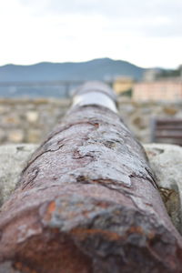 Close-up of rusty metal on land against sky