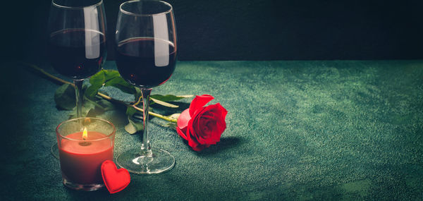 Red rose in glass on table