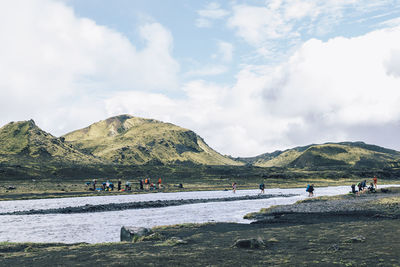 Adventurous hikers crossing river while hiking famous laugavegur trail in iceland