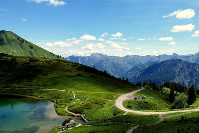 High angle view of winding road by mountains against sky