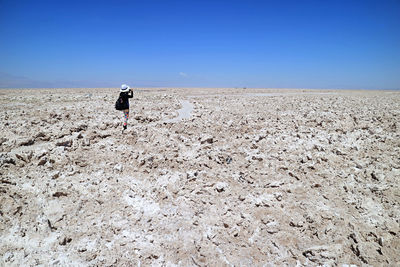 Female traveler taking photos on the trail of salar de atacama, extensive chilean salt flat, chile