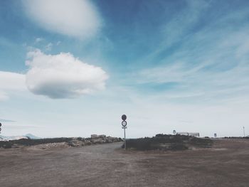 Road sign against sky